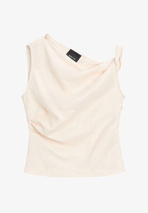 Top senza maniche color crema con scollo drappeggiato e bretella asimmetrica, con una piccola etichetta nera vicino al collo.