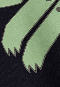 Diseño texturizado verde con puntas afiladas sobre un fondo oscuro, con contornos contrastantes. El material parece suave y mate.