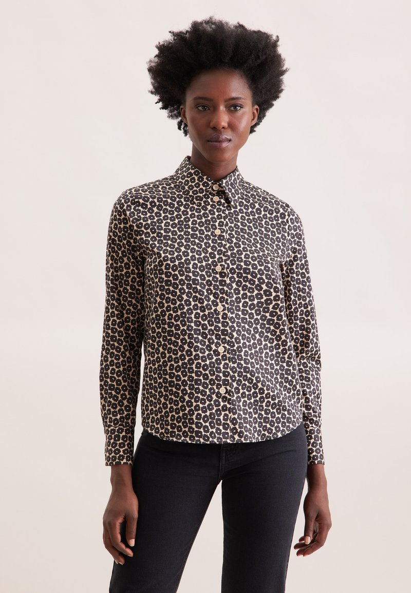 Camicia abbottonata con motivo floreale nero e beige, maniche lunghe e colletto. Realizzata in tessuto leggero. Caratterizzata da chiusura a bottoni.