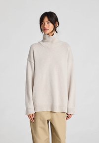 Beige, oversized coltrui met geribbelde zoom en manchetten, gemaakt van zachte gebreide stof, met verlaagde schouders en een comfortabele pasvorm.