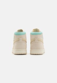 Sneaker alte in suede beige con collar e dettagli azzurri. Caratterizzate da suola in gomma bianca e pannelli laterali testurizzati per una migliore aderenza.