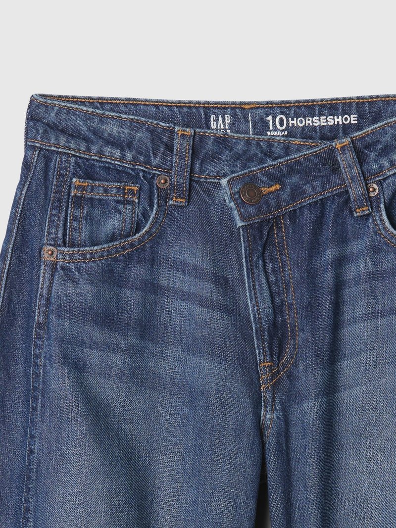 Dunkelblaue Denim-Jeans mit klassischem Fünf-Taschen-Design, Messing-Nieten, gelben Nähten und normaler Passform, mit einem Etikett, auf dem "Horseshoe" steht.