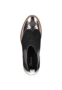 Scarpa slip-on in suede nero con punta metallica argento e perforazioni decorative. Presenta una suola in gomma e dettagli testurizzati.