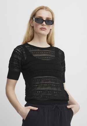 Black knit short-sleeve top featuring intricate openwork and patterned textures. Horizontal stripes with solid black cuffs and hem.