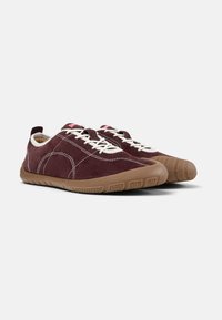 Chaussures en daim bordeaux avec semelle en caoutchouc, lacets blancs et coutures contrastées. Bout rond et design bas. Détail de semelle texturée.