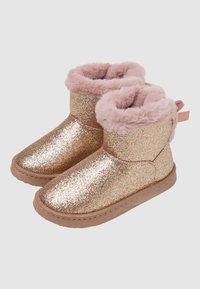 Stivaletti alla caviglia glitterati color oro rosa con una morbida fodera in pelliccia sintetica rosa, punta arrotondata e un accentuazione in nastro rosa sul retro. Suola in gomma piatta.
