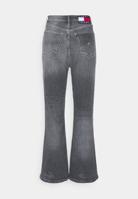 Gray flared jeans made of denim, featuring a mid-rise waistband with a logo tab, two back pockets, and a faded texture.