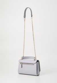 Borsa a tracolla in pelle grigia con chiusura a pattina, tasca frontale con zip e catene doppie. Texture liscia, forma strutturata e dettagli hardware in oro a contrasto.