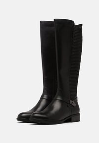 Botas negras hasta la rodilla con una parte delantera de piel suave y parte trasera de malla, que cuentan con un tacón ancho robusto y una correa decorativa con hebilla.