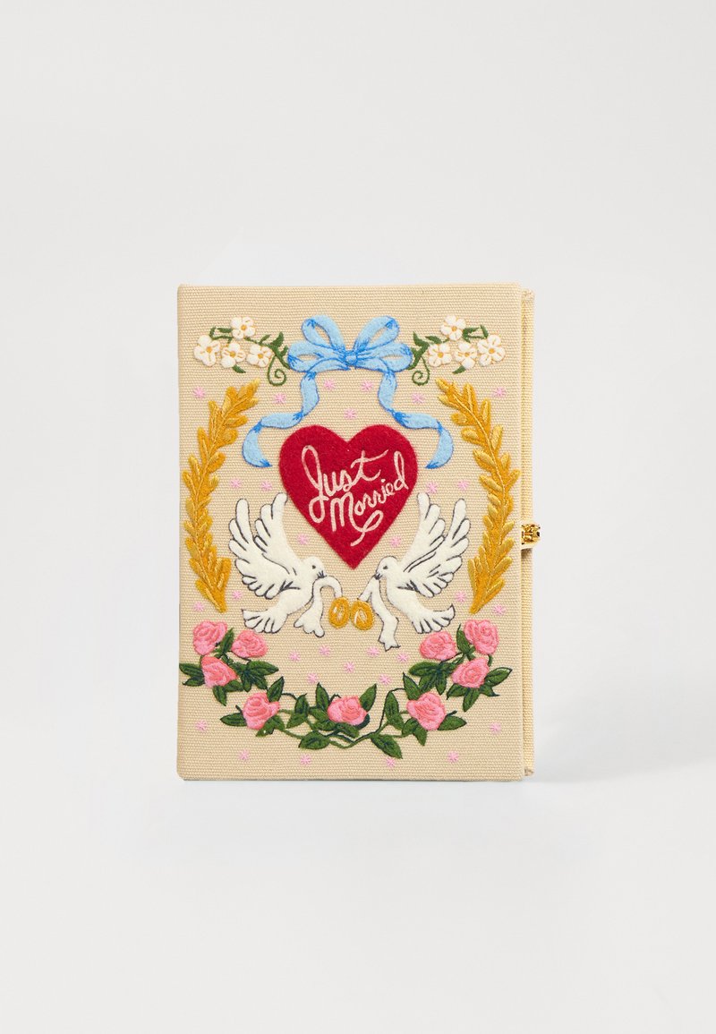 Výšivková svatební kniha hostů s béžovým textilním obalem, obsahuje červené srdce se štítkem "Právě jsme se vzali", bílé holubice, květinové akcenty a zlaté prsteny.