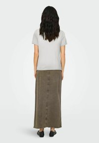 Camisa gris de manga corta combinada con una falda de mezclilla larga y verde oliva, con un corte recto y costuras visibles a lo largo de las uniones.