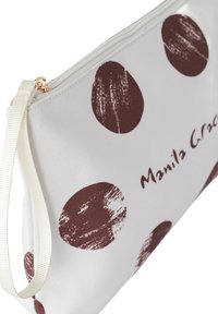 Borsa in tela bianca con grandi punti a tratto marrone, con cerniera dorata e una tracolla color crema. Logo "Manila Grace" stampato sul davanti.