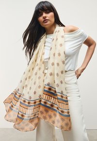 Lightweight, patterned scarf in cream with floral motifs, featuring stripes in blue and brown. Textured fabric drapes elegantly.