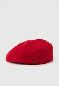 Rode wol beret met een klein zilveren schildvormig embleem aan de zijkant, weergegeven op een witte achtergrond.
