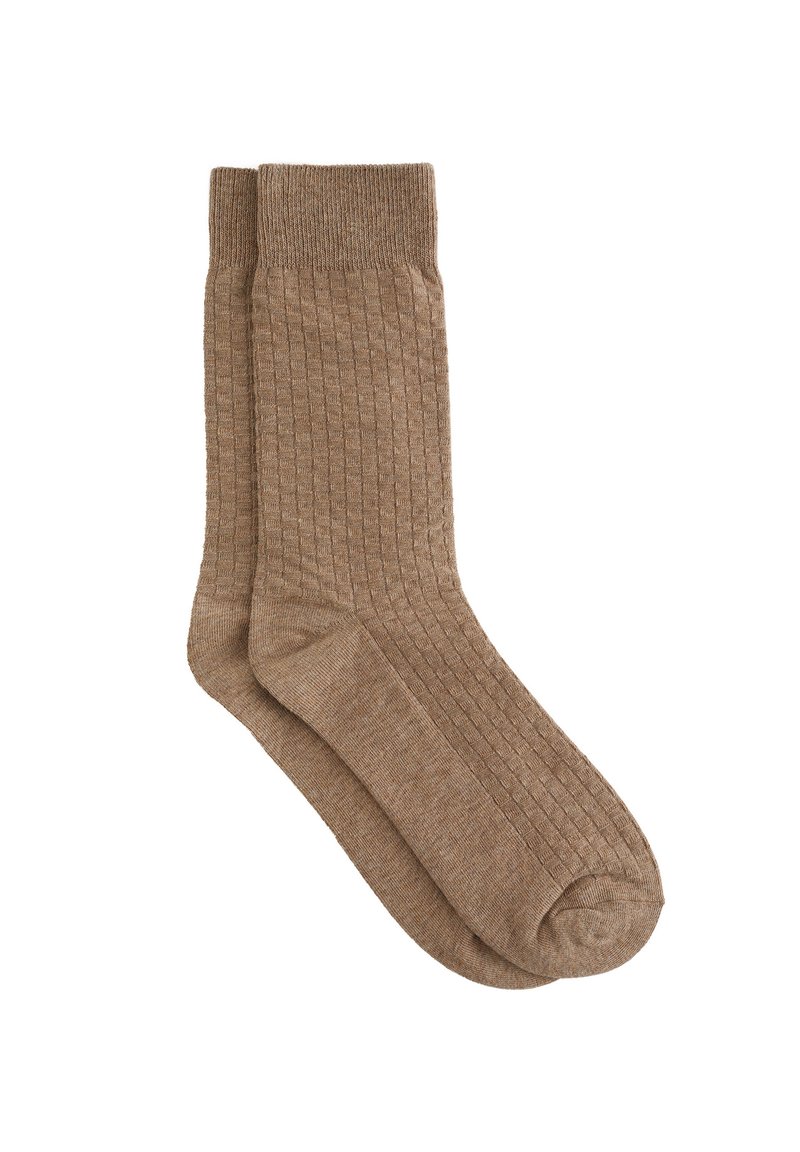 Rjave rebraste nogavice iz mehkega materiala. Opremljene so z ojačanimi petami in prsti, imajo srednjo dolžino ter gladko teksturo.