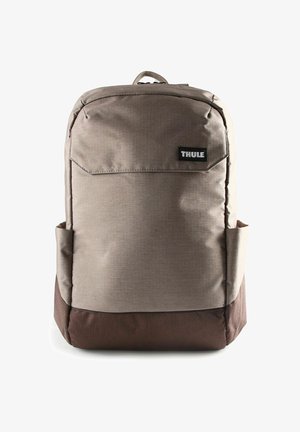 Sac à dos Thule marron et gris avec une finition en tissu texturé, une poche frontale et des poches latérales en mesh pour le rangement. Dispose de fermetures éclair robustes.