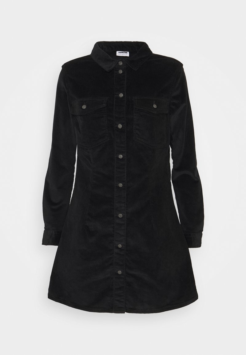 Robe chemise en velours côtelé noir avec des manches longues, un col pointu, une fermeture à boutons et deux poches poitrine. Texture lisse, ourlet au niveau des cuisses.