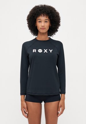 Svarte langermede rash guard med "ROXY"-logo i hvitt, laget av glatt, elastisk stoff. Har raglanærmer og flatlocksømmer.