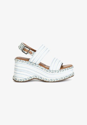 Sandale cu toc wedge, cu partea superioară din țesătură albă și albastră cu dungi, două curele late, detalii împletite la gleznă și o talpă texturată bej.