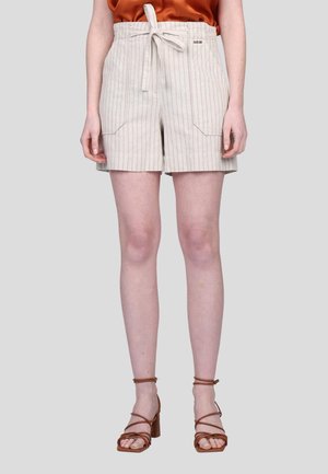 Shorts rayés beiges avec une taille à cordon de serrage, poches avant et coupe décontractée. Ils sont associés à des sandales à talons broux à anses.