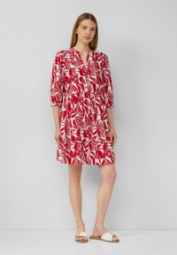 Rot-weißer gemusterter Hemdkleid mit V-Ausschnitt, Dreiviertelärmeln und gerafftem Taillenbereich, der über dem Knie endet.