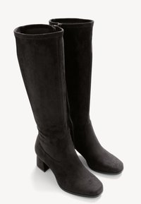 Mustat polvipituiset saappaat, jotka on valmistettu pehmeästä mokasta, neliöjalkapohjalla ja paksulla korolla, sivuvetoketjulla helpottamaan pukemista.