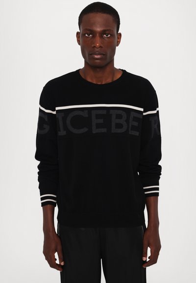 Pull en tricot noir à col rond, arborant un grand texte "ICEBERG", des rayures horizontales blanches sur les manches, ainsi que des poignets et un ourlet côtelés.
