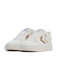 Białe sneakersy z jasnobeżowymi akcentami, wykonane z gładkiego materiału syntetycznego, z niskim krojem, perforowanym noskiem i sznurowanym zapięciem.