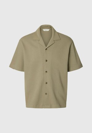 Beige kortærmet vævet skjorte med spredningskrave og fem knapper foran, vist på en ensartet lys baggrund.