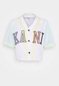 Maillot de baseball court blanc avec manches vert menthe. Présente un texte multicolore "KANI" et des bandes d'accent jaune, avec des boutons noirs.