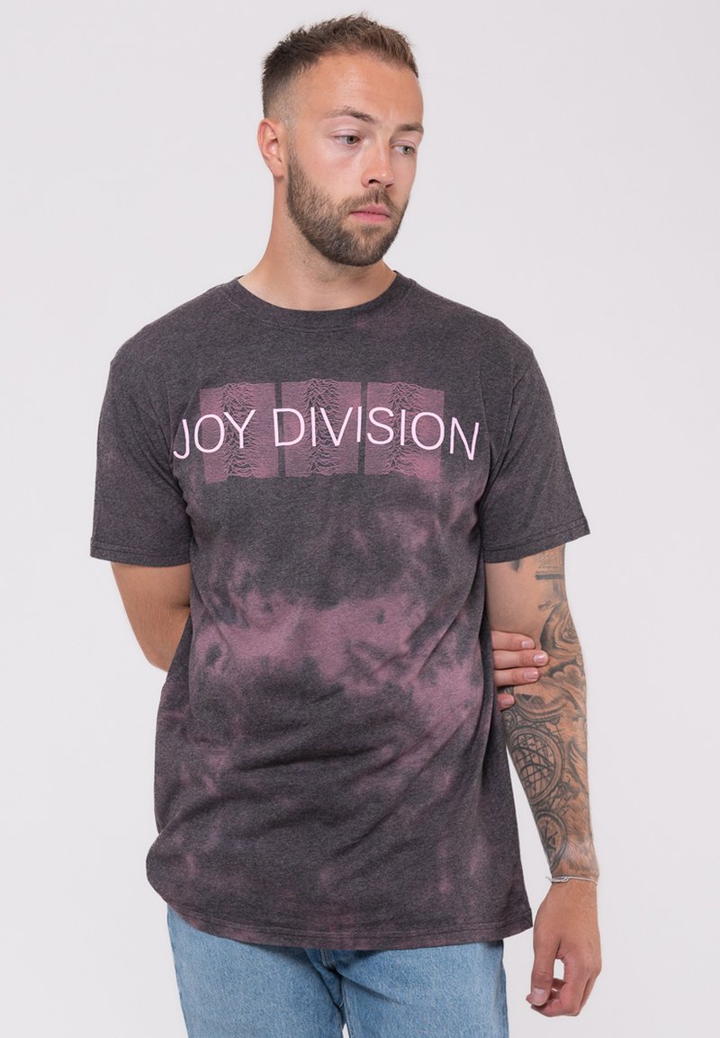 Dark gray t-shirt with a pink "Joy Division" graphic. Features a tie-dye pattern in shades of gray and pink. Short-sleeved, casual fit.