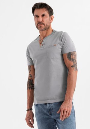 T-shirt Henley gris à manches courtes avec une poche, doté d'une patte de boutonnage à trois boutons et de boutons marron contrastants. Matière en coton douce, coupe décontractée.