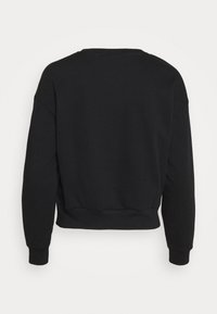 Sudadera negra recortada con un escote redondeado y mangas largas. Fabricada en un tejido suave con puños y dobladillo acanalados, textura lisa.