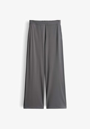 Graue Hose mit weitem Bein aus leichtem Stoff. Verfügt über einen elastischen Bund und zwei Seitentaschen. Glatte Textur mit klaren Linien.