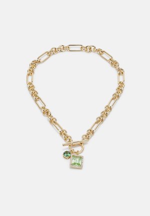 Złoty naszyjnik z łańcuszkiem, naprzemiennie z owalnych i okrągłych ogniw, wyposażony w zapięcie typu toggle i dwa zielone kamienie ozdobne w kształcie kwadratu i koła.