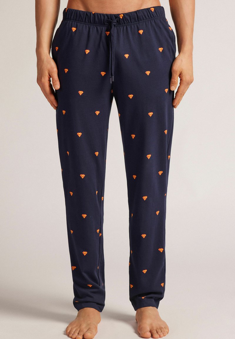 Navy pyjamasbyxor i mjukt tyg, med ett mönster av små orange diamanter över hela ytan, justerbar midja och ribbade muddar.