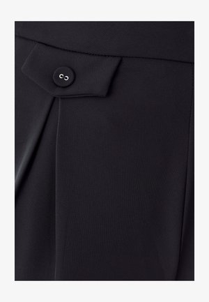 Sorte skræddersyede bukser med struktureret stof, glat front med plissering og en fremtrædende knapdetalje på taljen.