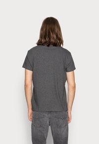 Grå bomulds t-shirt med korte ærmer og rund halsudskæring, der har en afslappet pasform. Bagv view viser ingen design eller mønstre.