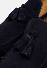 Navy blauw suède loafers met opvallende kwastaccenten. Bevat gestikte details en een gladde textuur, die een klassiek instapontwerp benadrukt.