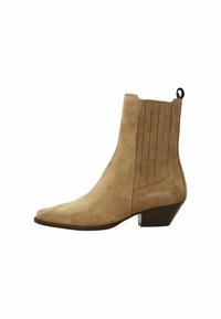 Bottines en suede beige à bout pointu, avec des panneaux latéraux texturés et un talon bas et épais. Présente une petite poignée à l'arrière pour un enfilage facile.