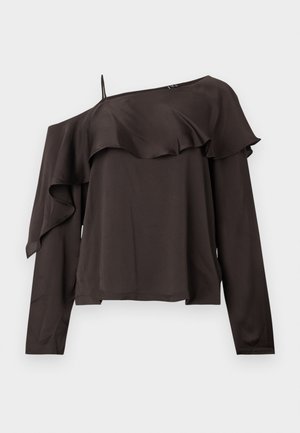 Bluză cu umerii la vedere, cu mânecă lungă, dintr-un material de culoare maro închis, cu un design volan în jurul tivului, având o curea subțire pe o parte.