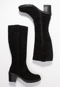 Bottes noires en daim montant jusqu'au genou avec un talon épais, un bout arrondi et une fermeture éclair latérale. Semelle texturée pour une meilleure adhérence et stabilité.
