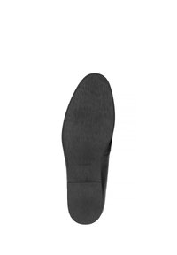Suola di scarpa nera con una finitura opaca e liscia. Forma leggermente arrotondata e design minimalista, con una texture sottile. Nessuna marcatura visibile.