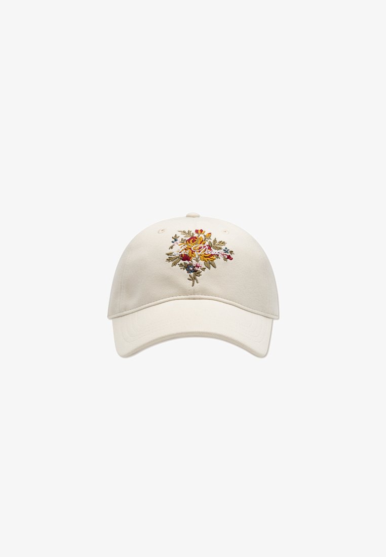 Kremfarget baseballcaps med brodert blomstermotiv i oransje, rødt og blått. Justerbar stropp bak; mykt bomullsmateriale.