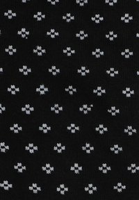 Czarna tkanina z powtarzającym się wzorem małych, białych kształtów przypominających krzyże. Materiał ma miękkie, teksturowane wykończenie.