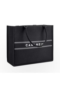 Black canvas tote bag with two round handles, featuring white "CARL HEINZ" text and two horizontal white stripes on the front.