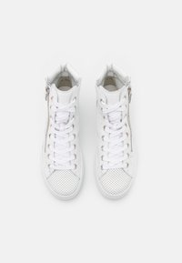 White high-top sneakers with perforated panels, flat laces, side zipper, and textured detailing on the toe cap.