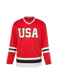Punainen jääkiekkopaita pitkähihaisilla, V-kaula-aukolla, valkoisilla ja mustilla raidoilla hihoissa ja alaosassa, ja "USA" painettuna paksuilla kirjaimilla etupuolella.