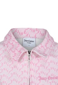 Giacca rosa con zip in texture morbida, caratterizzata da un pattern a logo ripetuto, tirazip in argento con 'J' e nome del marchio ricamato. Etichetta con taglia S visibile.