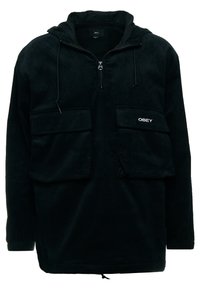 Black corduroy pullover with a hood, featuring a half-zip front and two front pockets. Includes adjustable drawstrings and elastic cuffs.